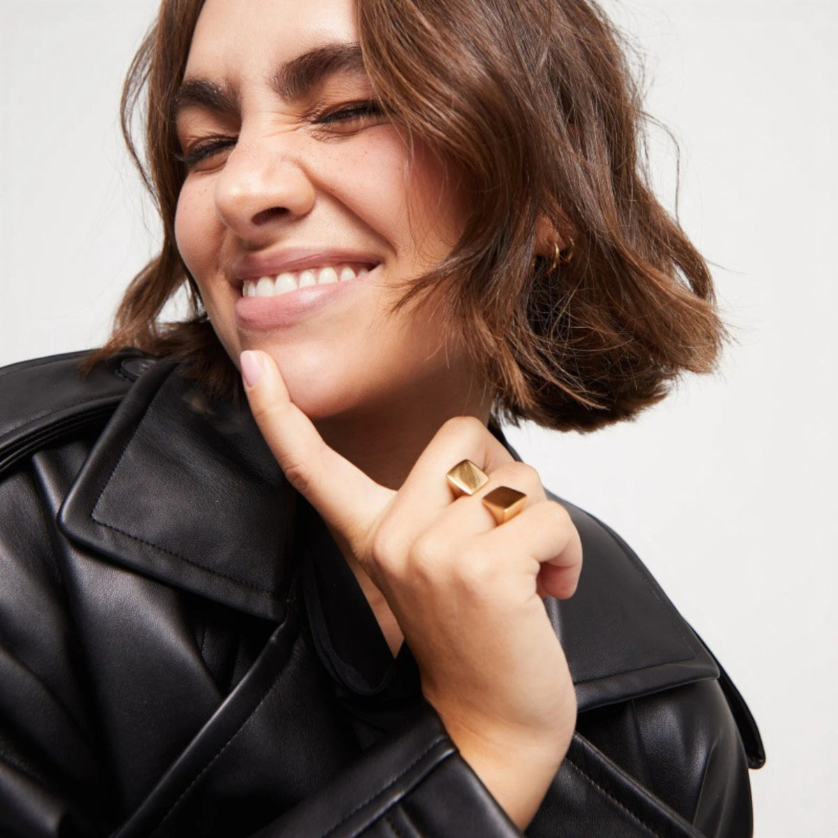Model wearing gold architectural open ring styled with leather jacket