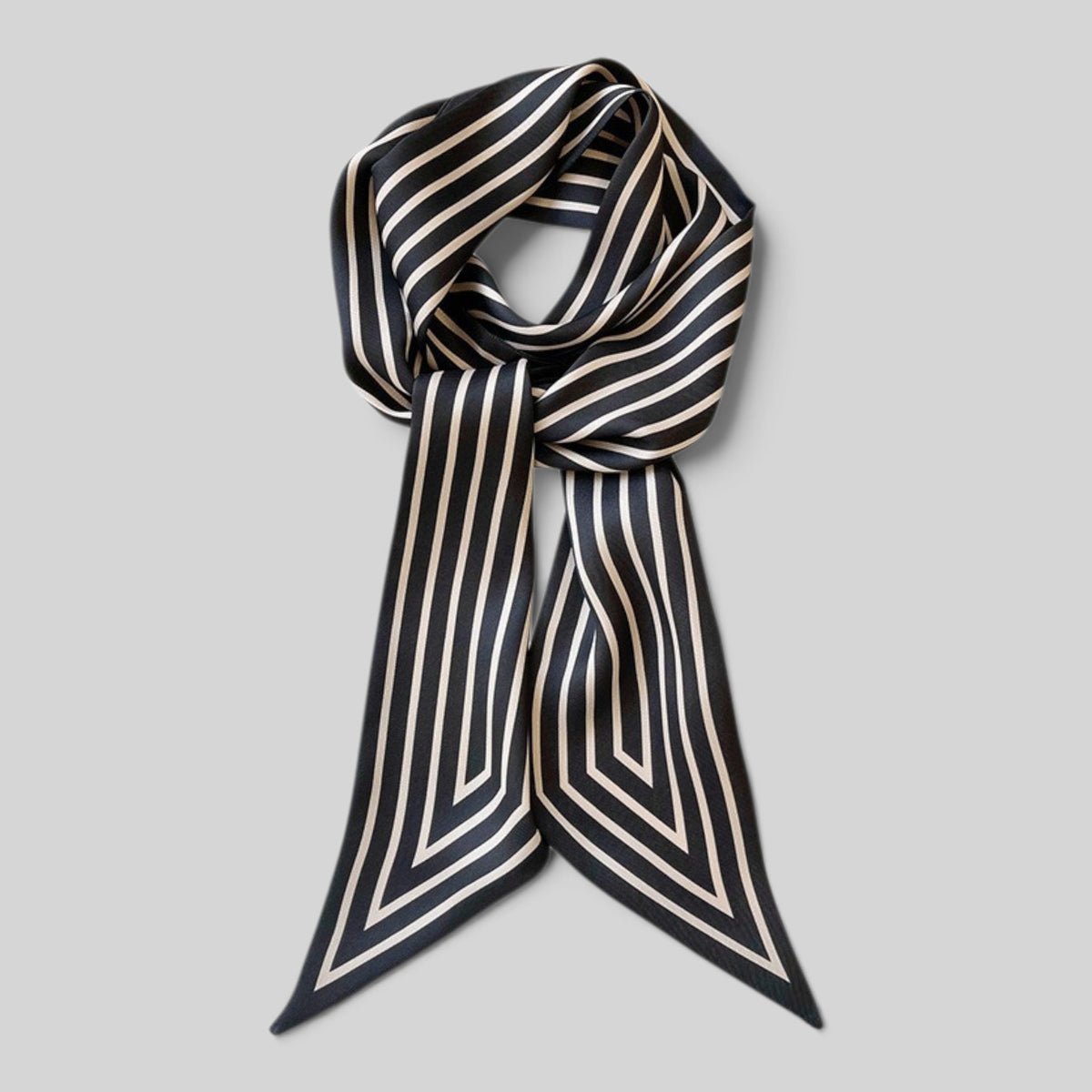A silk scarf with a black and beige geometric striped pattern, styled in a knot against a solid gray background.