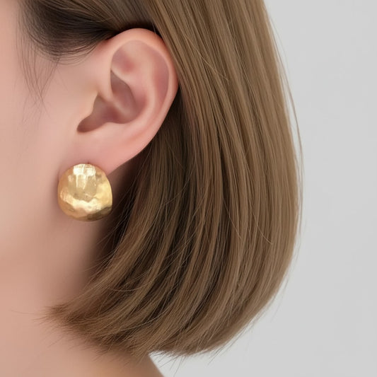 Model wearing hammered geometric hoop earrings with modern tailoring