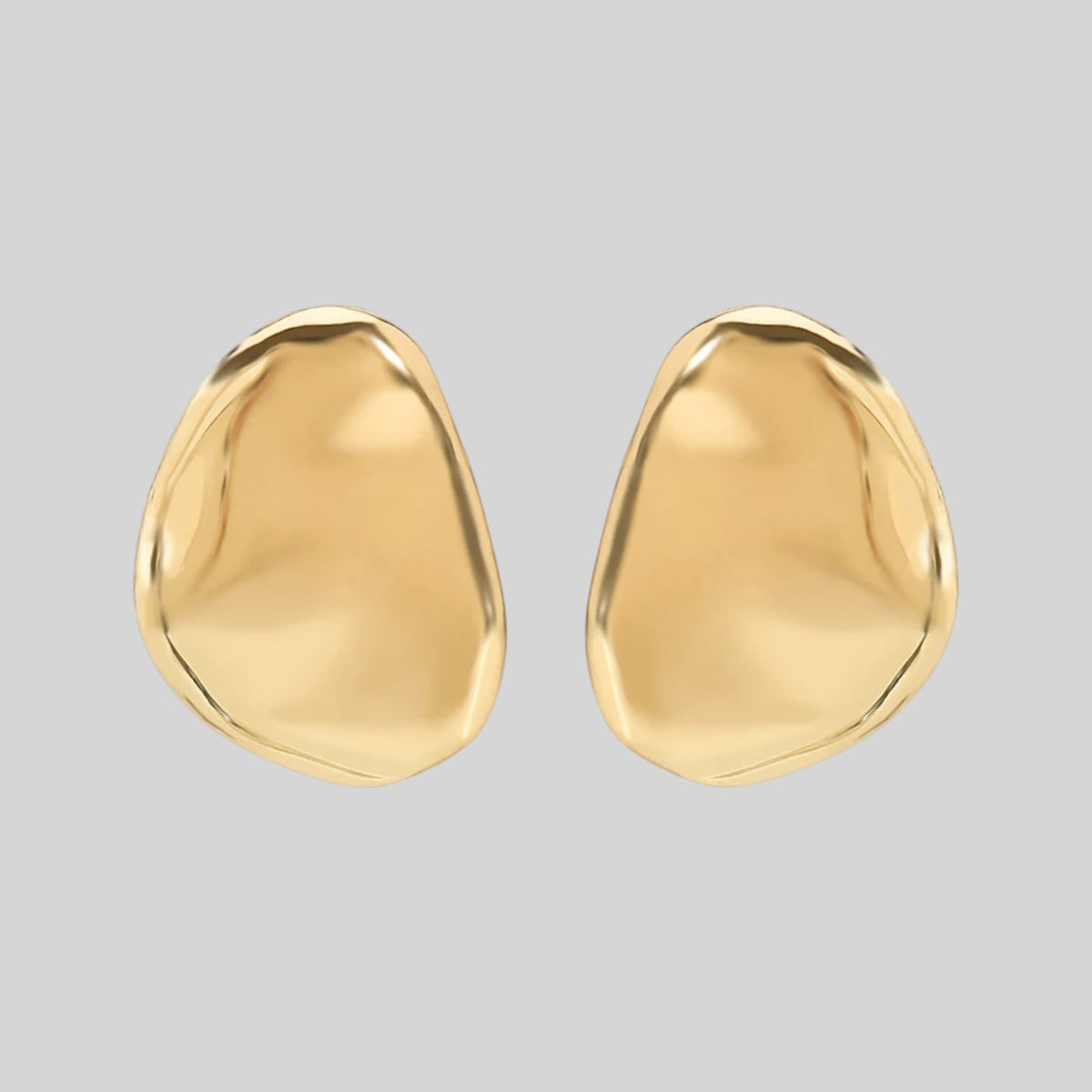 A pair of gold abstract teardrop-shaped earrings with a smooth, polished finish, displayed on a solid light gray background.