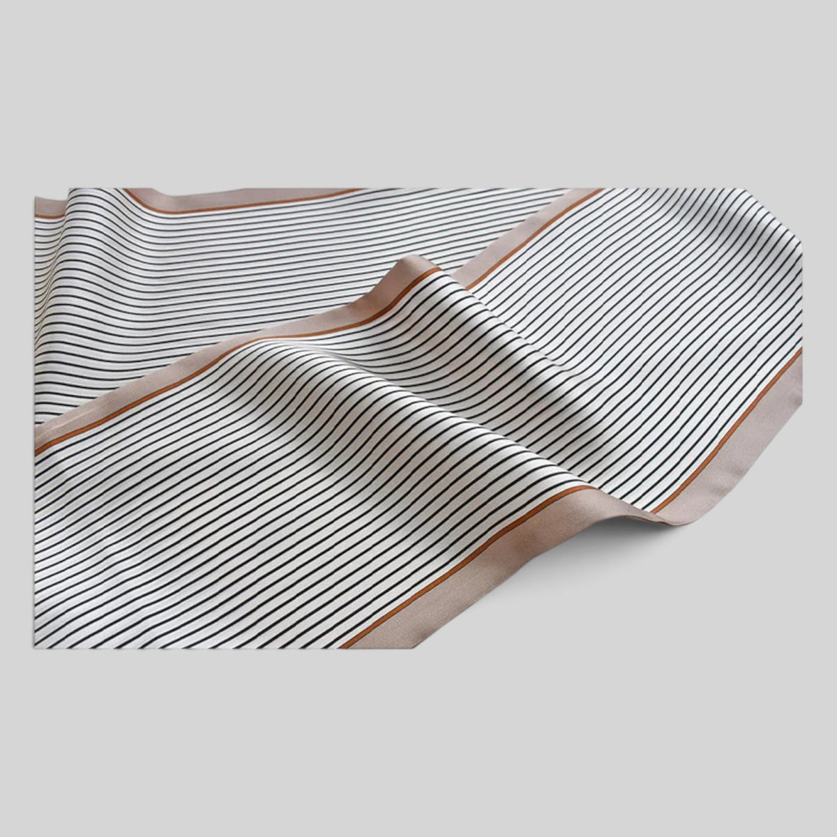 A square scarf with thin black stripes on a warm beige background and a solid tan border, draped elegantly on a light gray background.