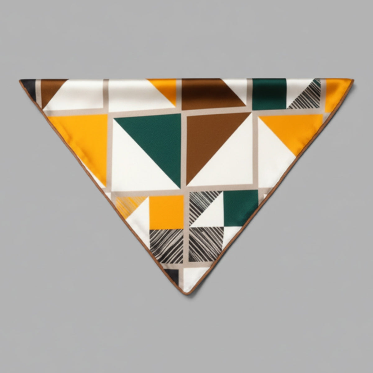 A triangular bandana with a geometric pattern of triangles in mustard yellow, forest green, brown, white, and black, displayed flat against a solid gray background.