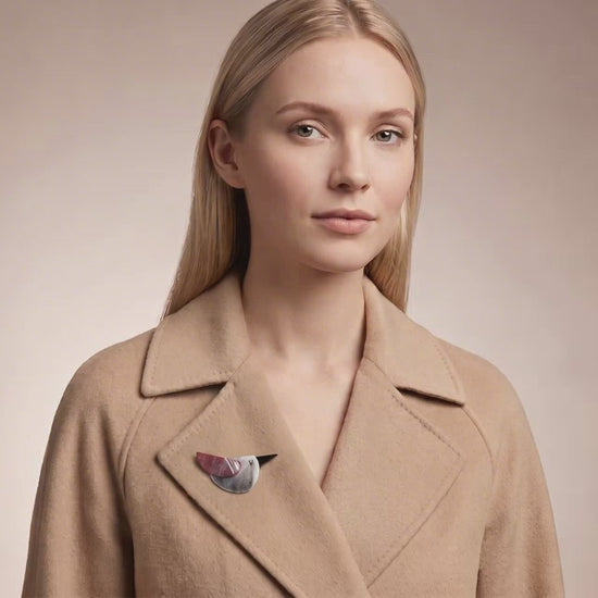Model wearing colorful acrylic bird brooch on a beige cachemire coat collar