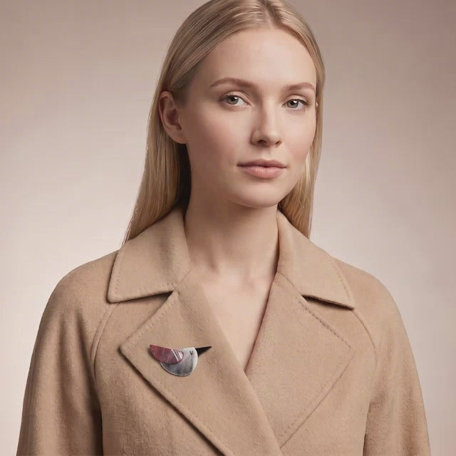 Model wearing colorful acrylic bird brooch on a beige cachemire coat collar